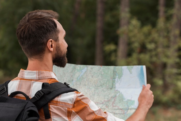 Man with backpack looking at map while camping