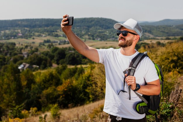 Man with backpack taking selfie