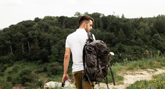 Uomo con zaino in viaggio nella foresta