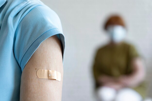 Man with bandage on arm after vaccination