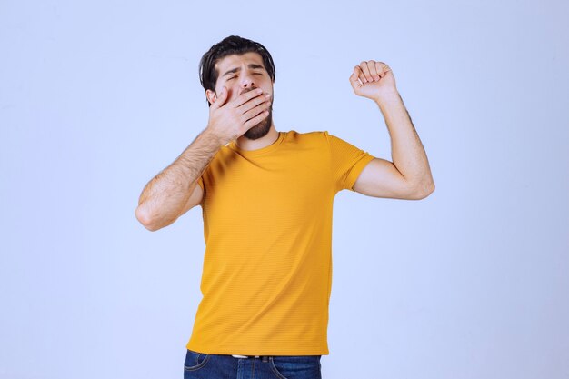 Man with beard covering his eyes as he is sleepy