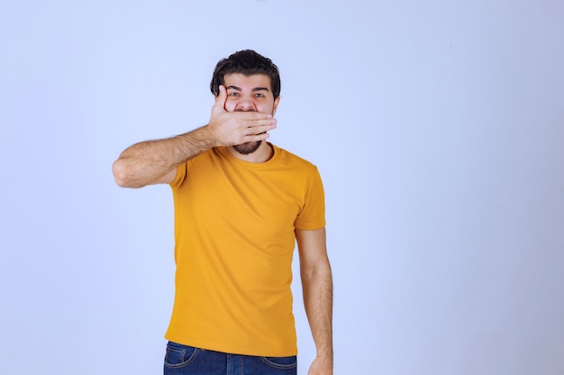 Uomo con la barba che si copre parte del viso e ride