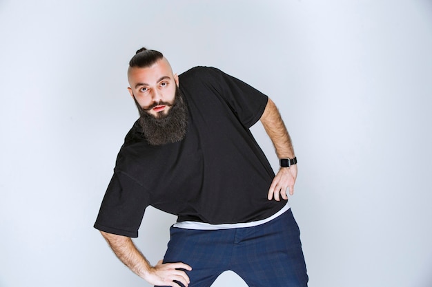 Foto gratuita uomo con la barba che balla o dà pose straordinarie.