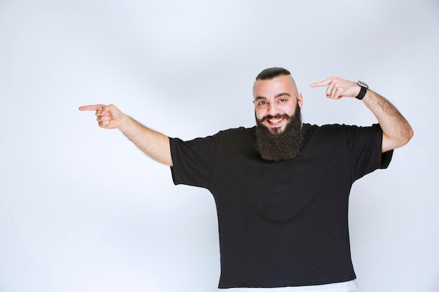 Free photo man with beard demonstrating his arm muscles and fists.
