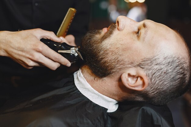 あごひげを生やした男。クライアントと美容師。髭剃りの男。