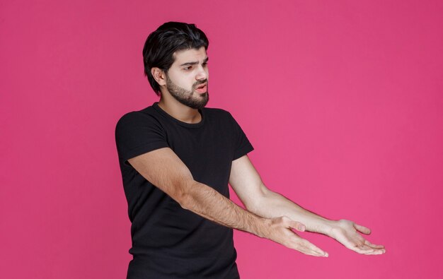 Foto gratuita l'uomo con la barba sembra confuso e inesperto riguardo a qualcosa