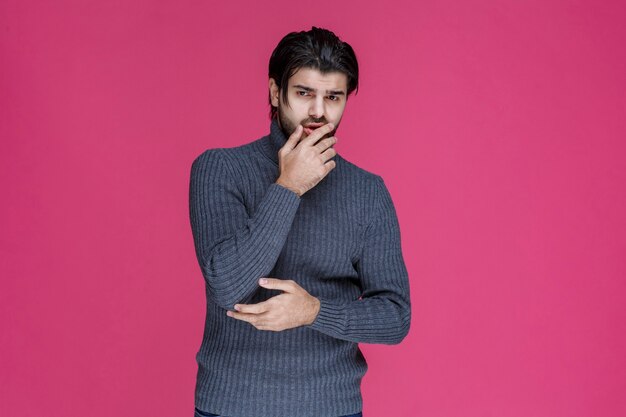 L'uomo con la barba sembra perso e pensieroso.