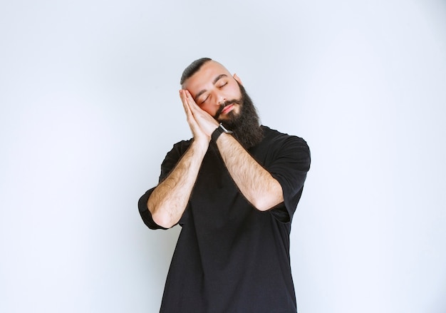 L'uomo con la barba sembra assonnato e stanco.