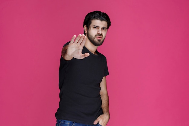 Man with beard making rejection hand sign.