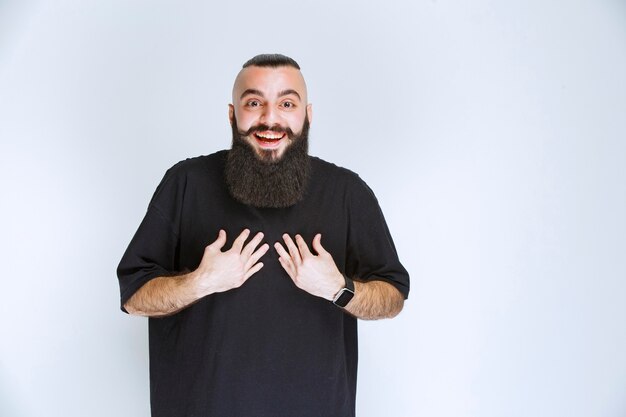 Man with beard pointing at himself.