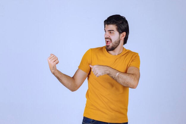 Man with beard pointing at something behind