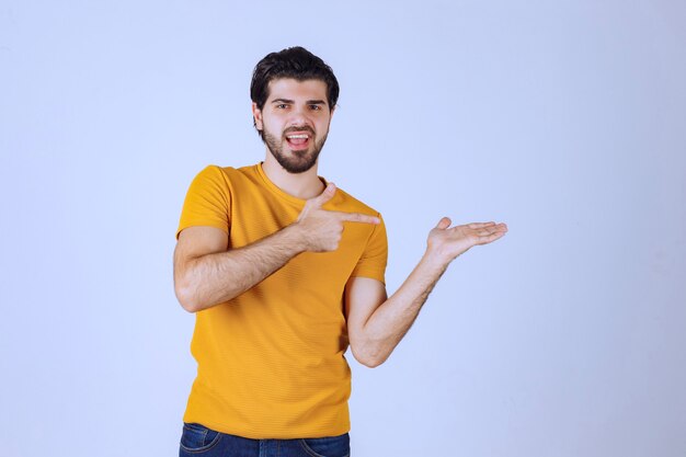 Man with beard presenting something in his open hand