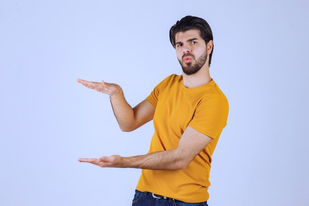 Man with beard showing estimated measures of an object. 