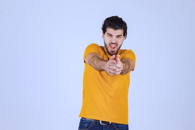 Free photo man with beard showing hand gun sign