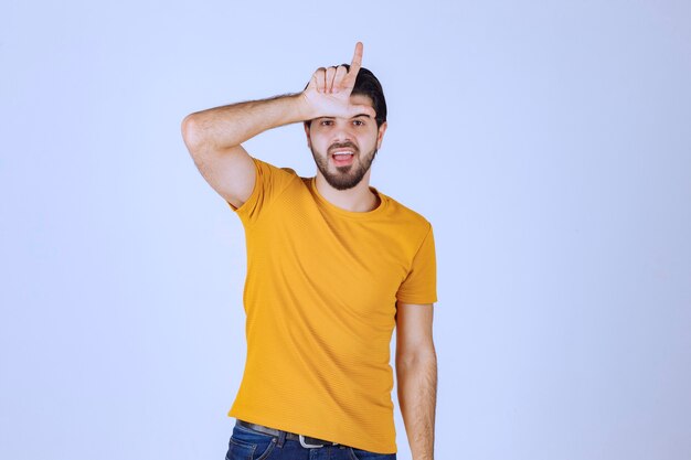 Man with beard showing loser hand sign.