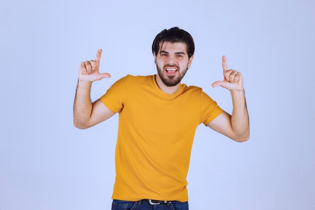 Man with beard showing loser hand sign.