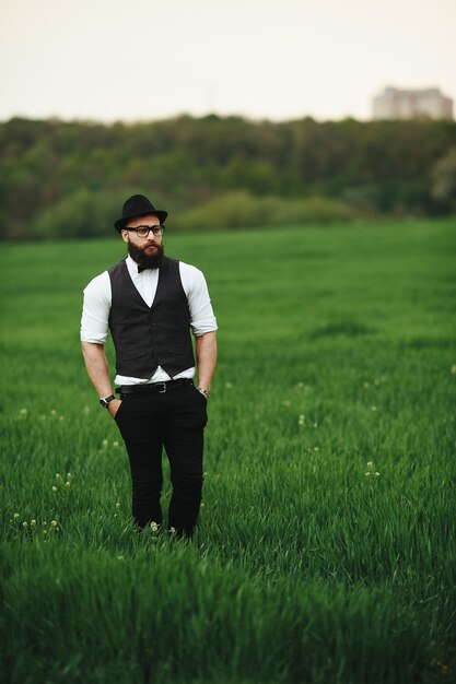 A man with a beard and sunglasses walking on the field