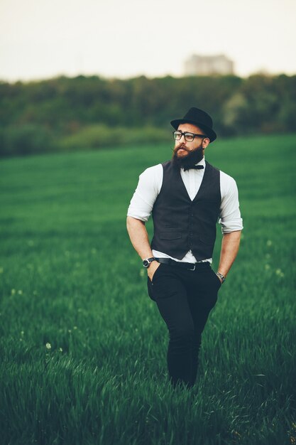 A man with a beard and sunglasses walking on the field