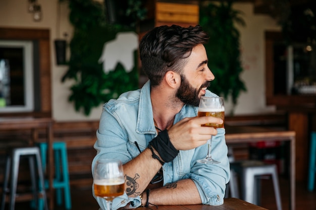 彼の左を見てビールを持つ男