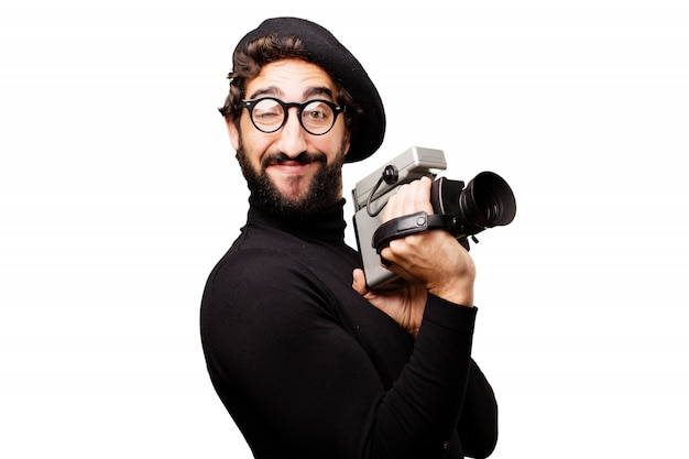 Free photo man with a beret and glasses to watch with an old camcorder