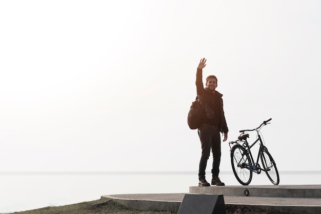 無料写真 海の背景に自転車を持つ男