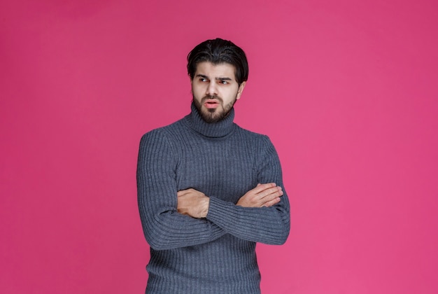 L'uomo con la barba nera sembra esausto e annoiato.