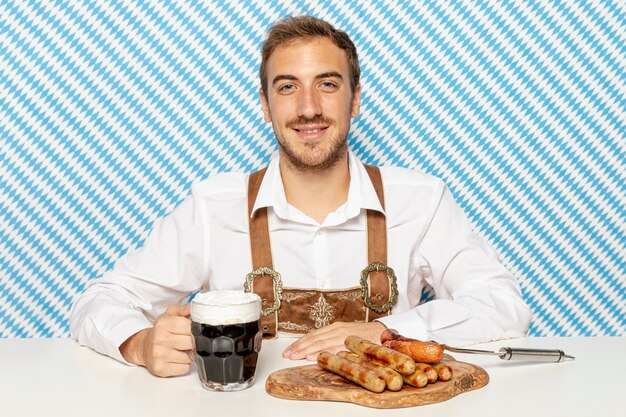 Man with black beer and sausages