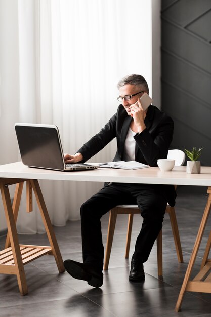 Man with black jacket sitting at the desk