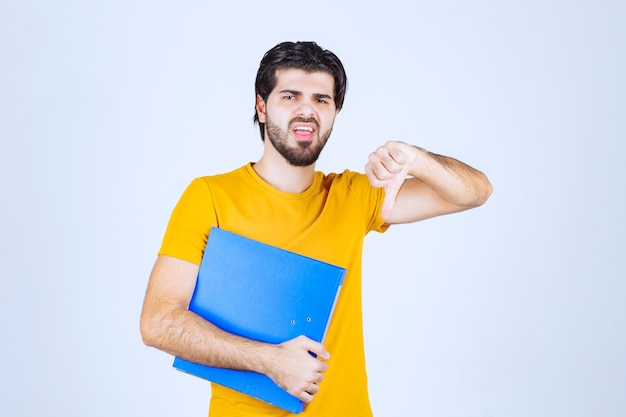 親指を下にやっている青いフォルダーを持つ男。