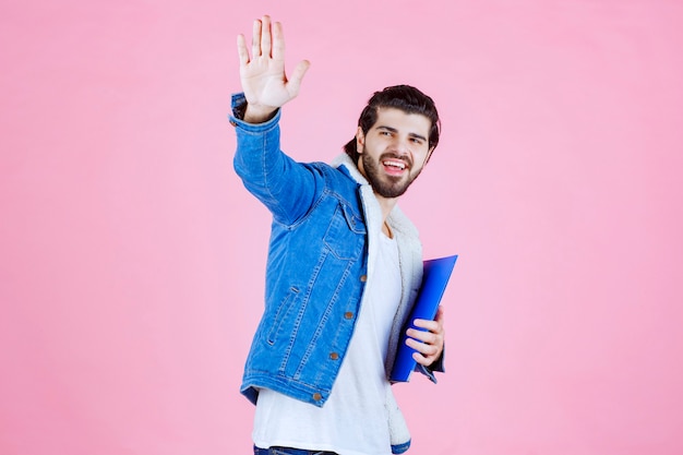 彼の同僚に挨拶する青いフォルダーを持つ男