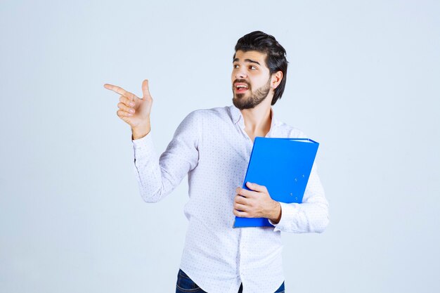 左側に同僚を紹介する青いフォルダーを持つ男