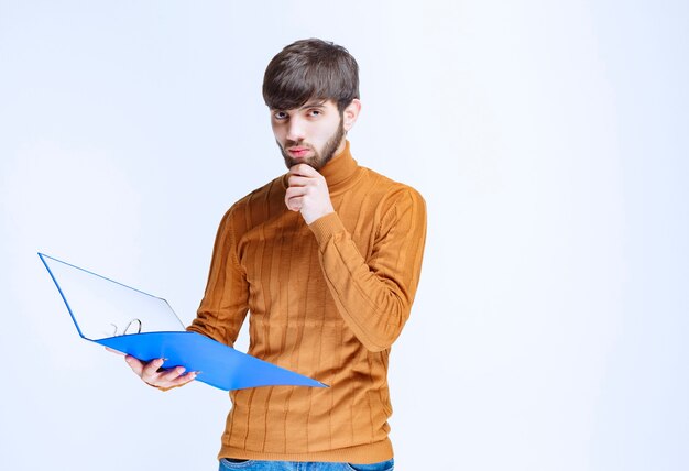 Man with a blue folder looks confused and terrified.