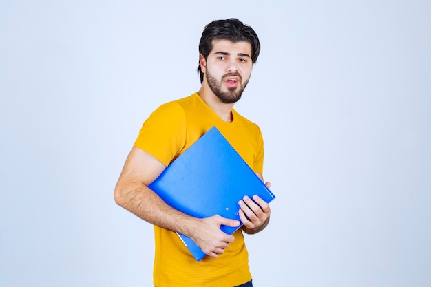 Man with a blue folder looks confused or unexperienced.