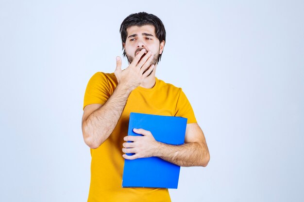 Free photo man with a blue folder looks confused