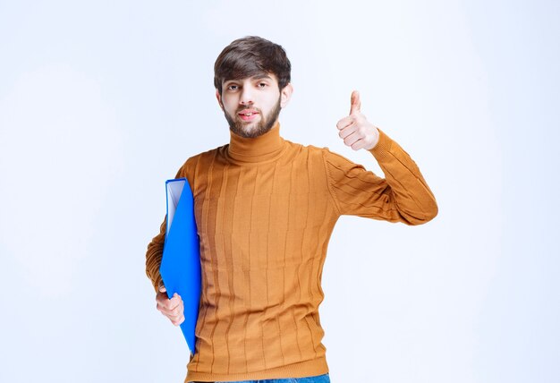 Man with a blue folder looks powerful and satisfied.