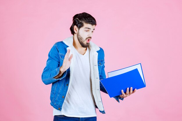 Man with a blue folder looks terrified and tired