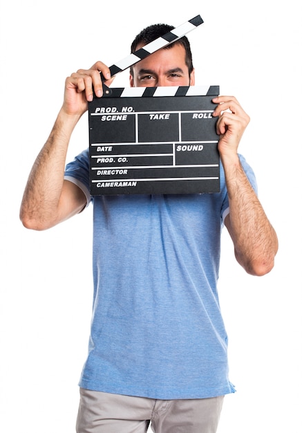 Man with blue shirt holding a clapperboard