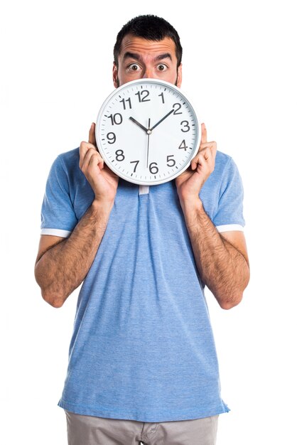 Man with blue shirt holding clock