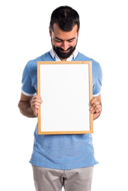 Man with blue shirt holding an empty placard