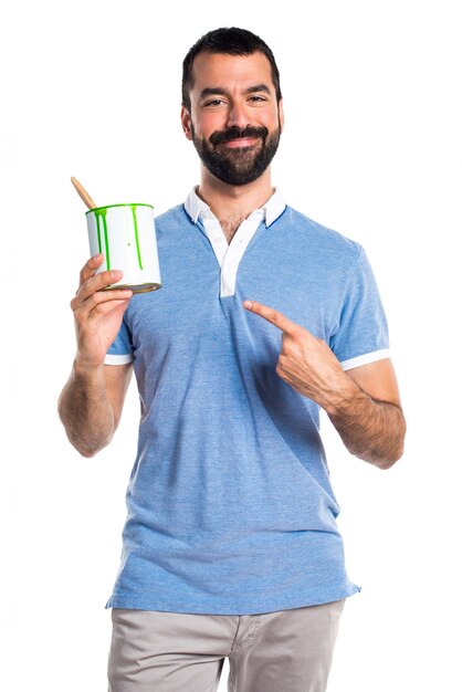 Man with blue shirt holding a paint pot