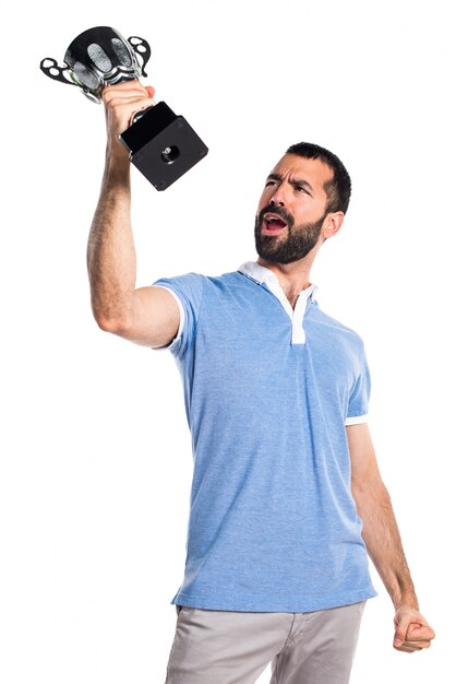 Man with blue shirt holding a trophy