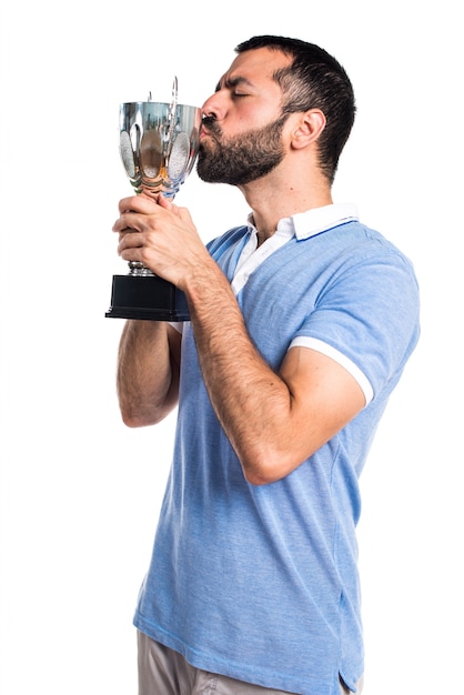 Man with blue shirt holding a trophy