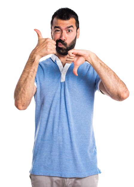 Man with blue shirt making good-bad sign