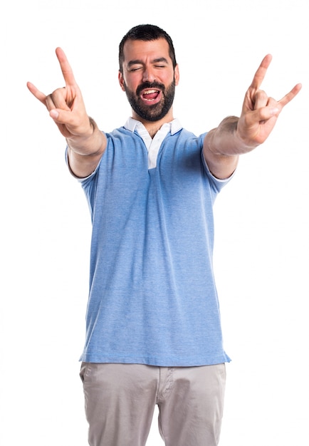 Man with blue shirt making horn gesture