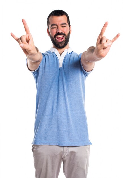 Man with blue shirt making horn gesture