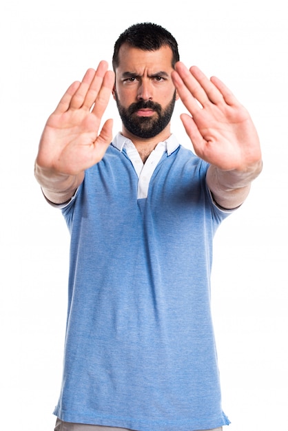 Man with blue shirt making stop sign