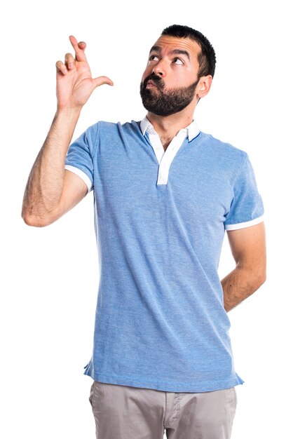 Man with blue shirt with his fingers crossing