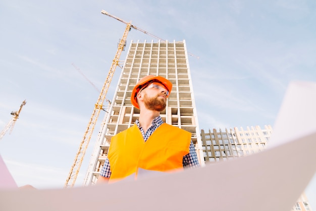 Man with blueprint looking away