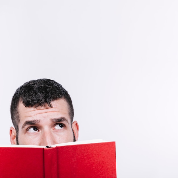 Foto gratuita uomo con il libro alzando lo sguardo