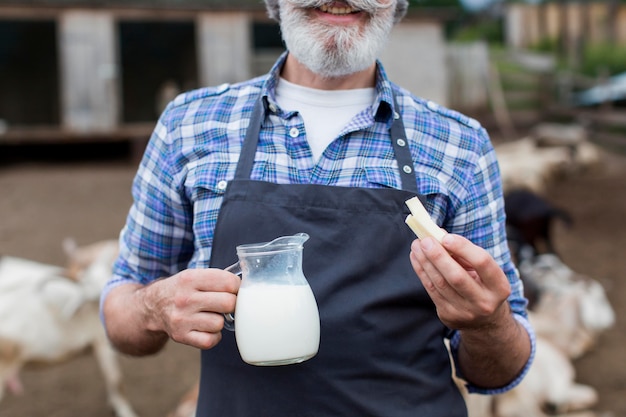 Foto gratuita uomo con una bottiglia di latte di capra di close-up